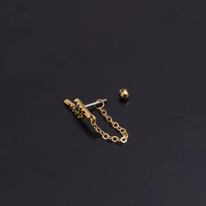 Detailed close-up of golden stainless steel piercing earring with zircon and chain link