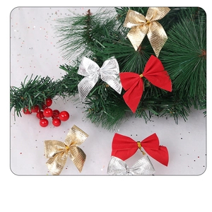 Close-up of red, gold, and silver Christmas bows with ties on green pine branches