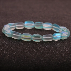 Macro shot of light blue moonstone beads and micro-pave zircon ball on a black surface