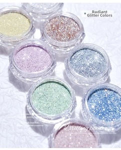 Macro shot of shimmering colorful nail glitter powders in pastel jars on white background