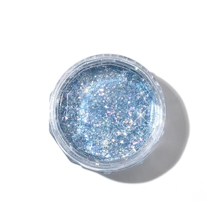 Sparkling blue glitter nail art powder in a clear jar for professional manicure decoration