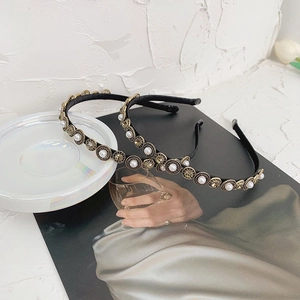 Close-up of baroque headbands with pearls and brown crystals on a ceramic tray