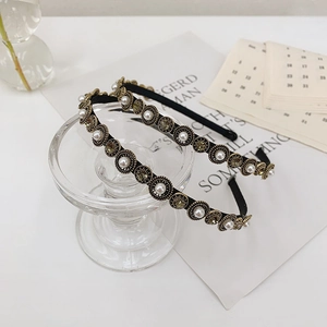 Close-up of baroque headbands with pearls and amber crystals on a display stand