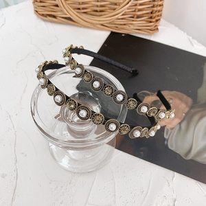Detail of baroque slim headband featuring amber crystals and white pearls on gold settings