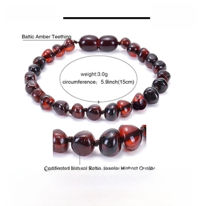 Macro detail of natural dark Baltic amber beads on 15cm baby teething bracelet