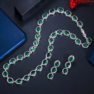 Elegant emerald green zircon necklace and earrings set displayed on dark artistic backdrop