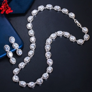Detailed view of silver jewelry set with oval cut zircons on an elegant dark background