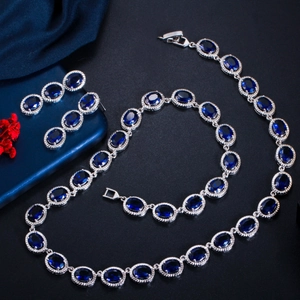 Detailed view of silver necklace and earring set with deep blue oval zircon stones