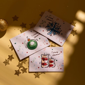 Three Christmas cards with snowflake and candle designs on a festive gold star background
