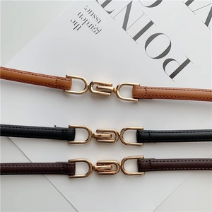 Three minimalist skinny waist belts in black, brown, and dark tan with gold metal buckles