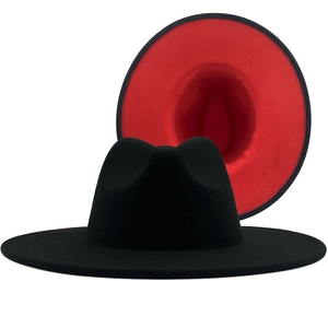 Detail of classic wide brim fedora hat featuring black exterior and red interior lining