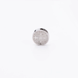 Macro view of silver stainless steel Saint Benedict medal charm with detailed engravings