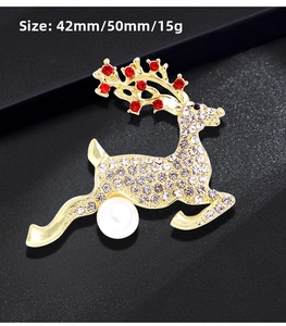 Detail view of gold reindeer brooch with red rhinestones and pearl showing dimensions