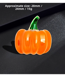 Detail view of pumpkin brooch with orange enamel and rhinestones showing 28mm size