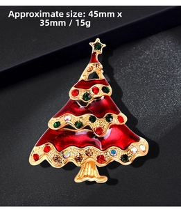Macro detail of Christmas tree brooch with colorful rhinestones and red enamel coating
