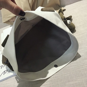 White canvas tote bag with brown straps showing spacious interior and magnetic snap closure