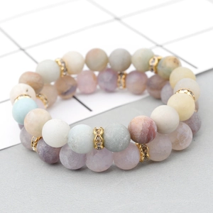 Macro detail of natural stone bead bracelets with gold spacer charms and matte finish