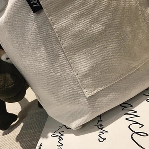 Detail of minimalist canvas tote bag showing tight weave texture and precise stitching