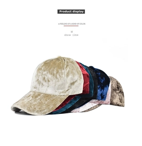 Detailed stack of colorful velvet baseball caps showing soft texture and glossy finish