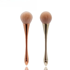 Close-up of rose gold foundation brushes with soft synthetic bristles on white background