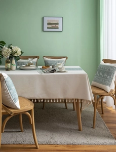 Close-up of beige linen tablecloth with gray-green runner and elk pattern cushion