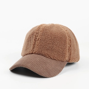 Detail of brown fleece baseball cap showing corduroy brim texture and plush crown fabric