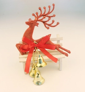 Detail of red glitter reindeer ornament with festive red bow and three golden bells
