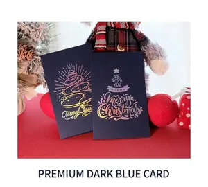 Detail of laser gold stamping Christmas tree on dark blue card with festive pine cone decor