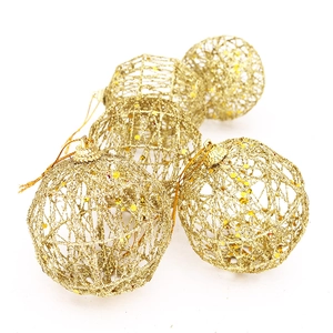 Close-up of golden hollow wire mesh Christmas balls with sparkling glitter and hanging loops