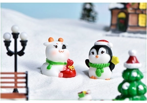 Miniature resin cow and penguin figurines in a festive snowy Christmas micro landscape