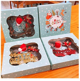 Detail view of Christmas hair accessory gift boxes with festive reindeer and hat themes