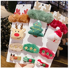 Close-up of festive plush Christmas hair clip set with reindeer and tree motifs