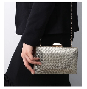 Detail of champagne gold evening clutch featuring a luxury chevron glitter texture
