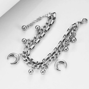 Detailed macro view of silver double-layer Cuban chain with moon and bead charms