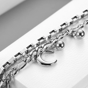Close-up of double-layer stainless steel Cuban chain with moon pendant and beads