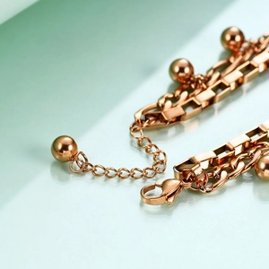 Detail of rose gold double layer Cuban link bracelet with round beads and lobster clasp
