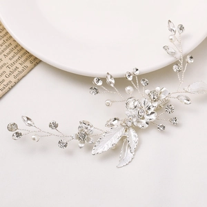 Detailed view of silver leaf hair clip with rhinestones and pearls on a white background