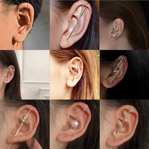 Detailed close-up of zircon crawler earrings in gold and silver finish on a model's ear