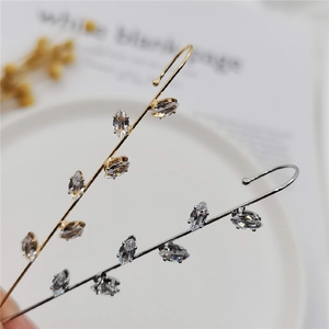 Detail of gold and silver leaf vine ear cuffs with sparkling marquise cut zircons