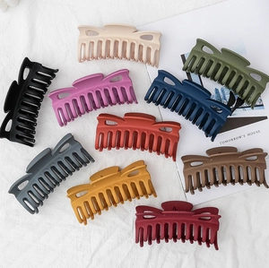 Close-up of matte large hair claw clips in various colors including mocha and burgundy
