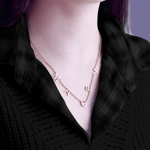 Close-up of rose gold MACEY letter pendant necklace on model with crossbody chain