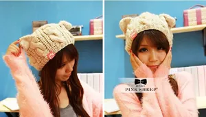 Detail view of cat ears on cable knit beanie showing thick texture and woven label