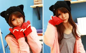 Detail of knit cat ear beanie with black ribbons and red knitted gloves set