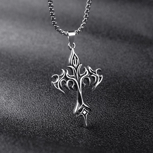 Macro shot of silver stainless steel cross pendant with ornate vintage textures
