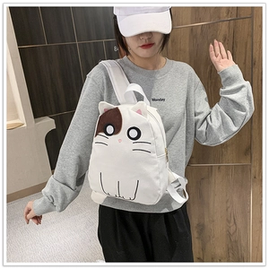 Close-up of a girl wearing a cute white cat-shaped canvas backpack in a casual setting
