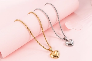 Detail of gold and silver heart pendants with beaded edges on elegant rope chains
