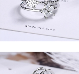 Detail view of silver double-layered open ring with sparkling flower and zircon inlay
