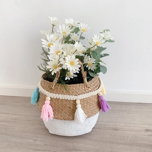 Detail of woven seagrass basket featuring colorful tassels and white crochet lace trim
