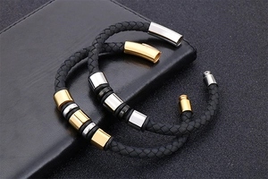 Detail of black woven leather bracelet with gold and silver steel clasp and inserts