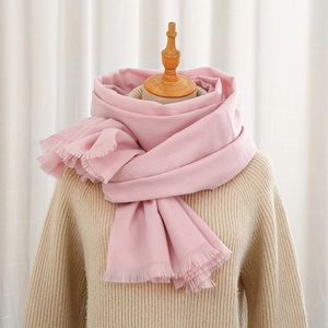 Detail of soft pink cashmere-like scarf with dense fringe on a display mannequin